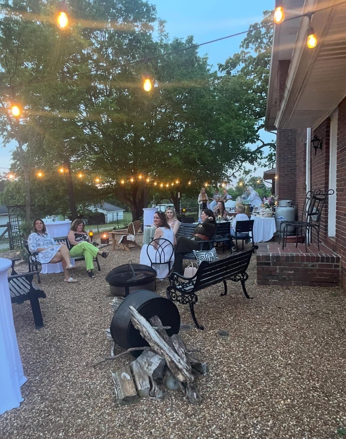 A group of people are sitting around a fire pit.