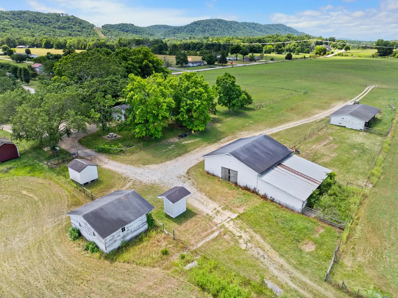 An aerial view of a farm with a lot of buildings and trees.