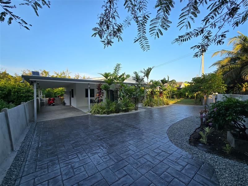 A driveway leading to a house with a covered driveway
