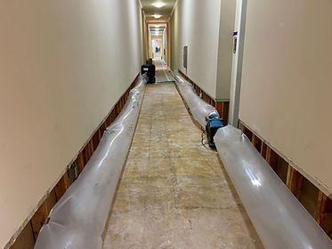 A long hallway with plastic bags on the floor and walls.