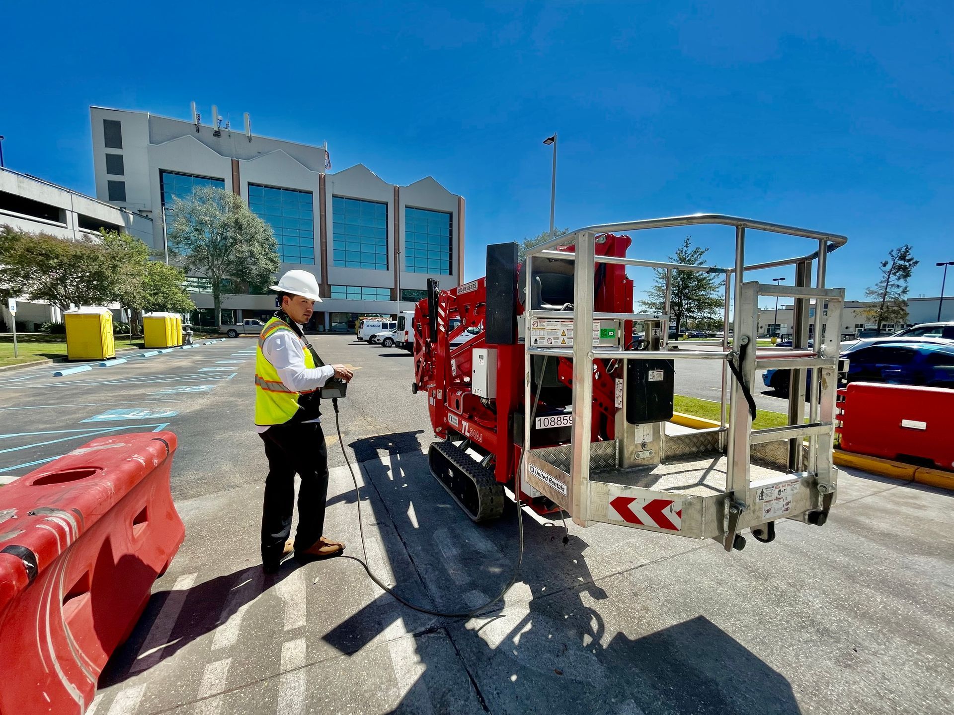 A person is holding a thermometer in their hand in front of pipes.