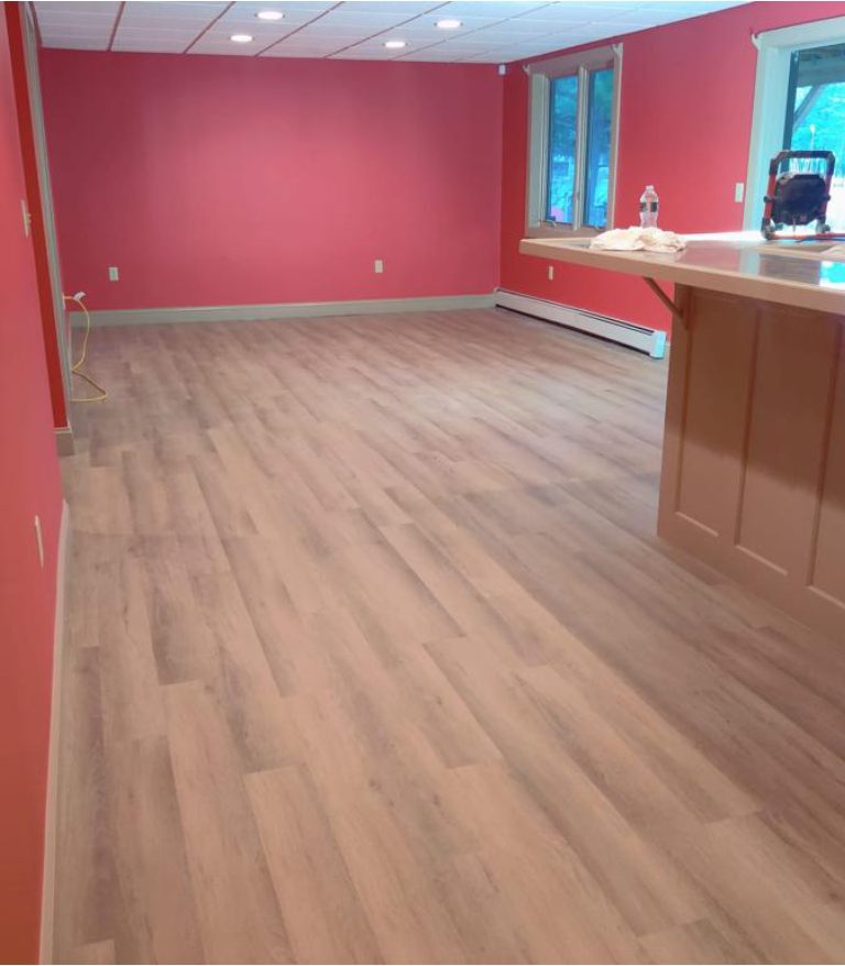 An empty room with red walls and wooden floors
