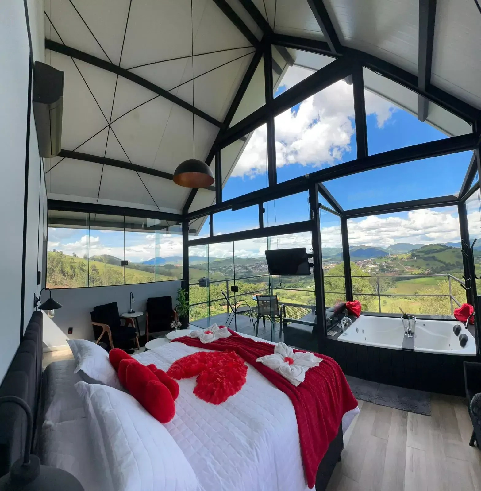 Um quarto com uma cama grande e uma banheira de hidromassagem Chalé Pedra Negra