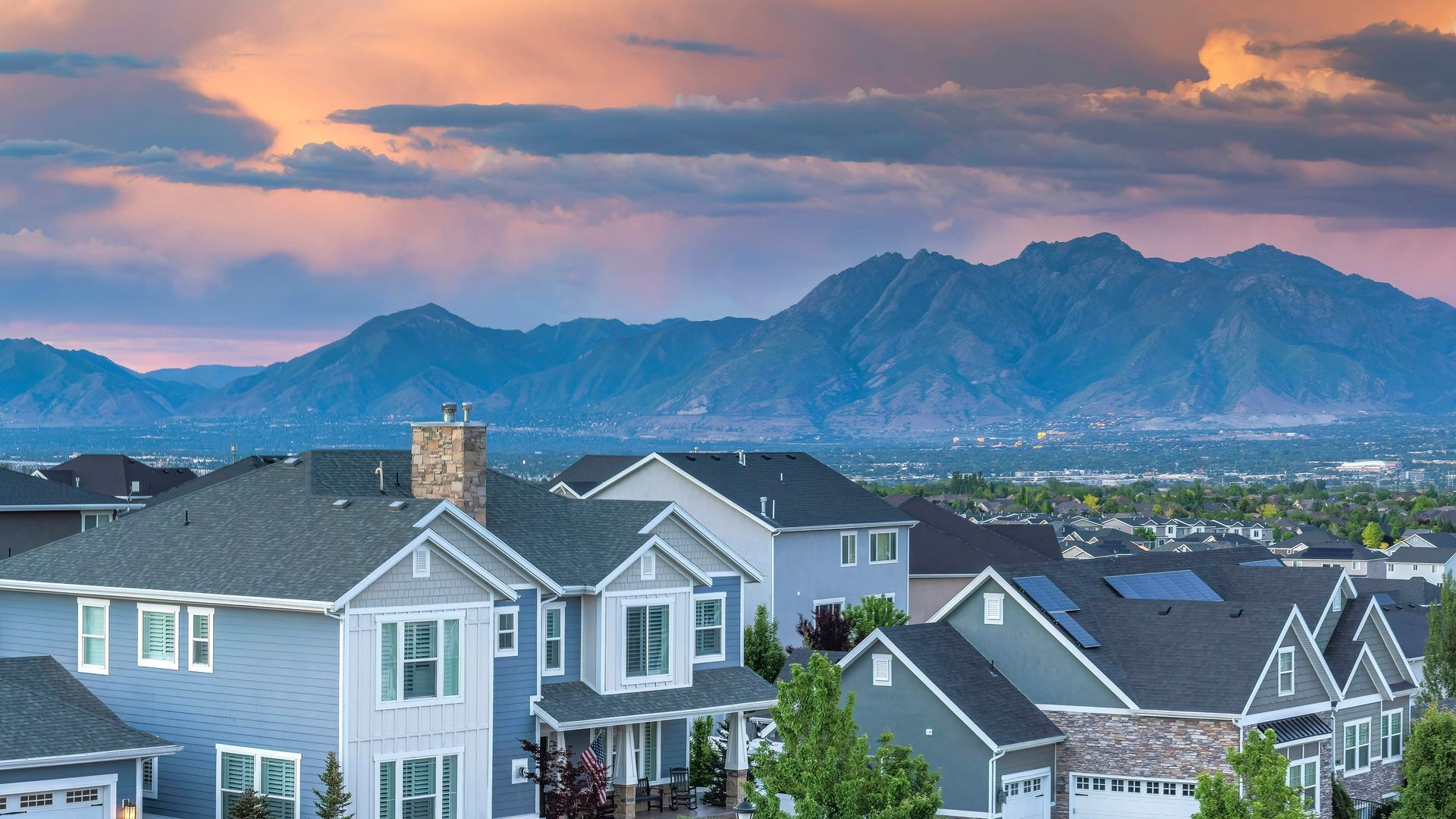 A row of houses with mountains in the background.