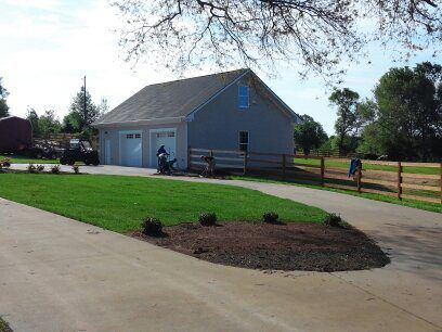 A man is riding a motorcycle in front of a garage.
