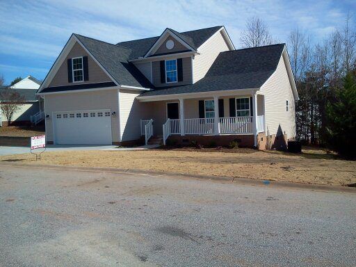 A house with a porch and a garage is for sale