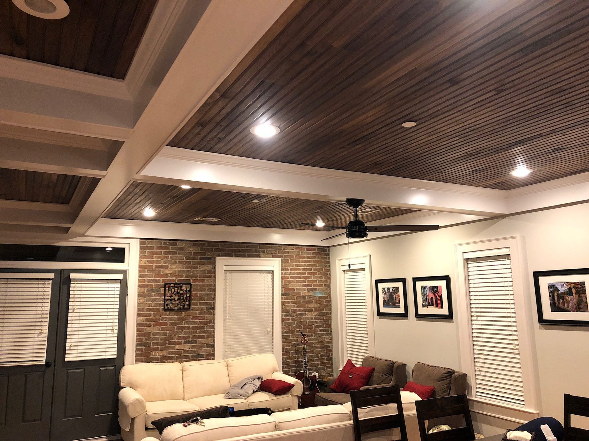A living room with a couch , chairs , and a ceiling fan.