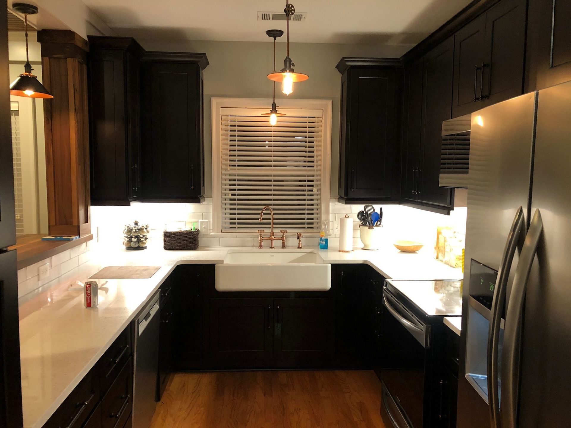 A kitchen with black cabinets and stainless steel appliances