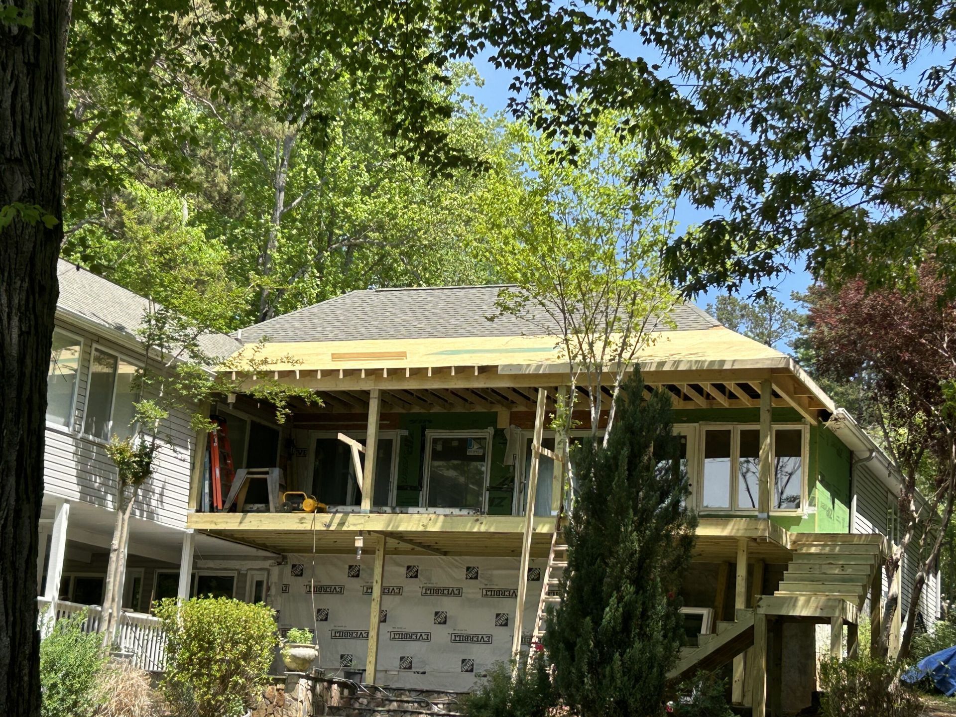 A house is being remodeled with a deck and a roof.