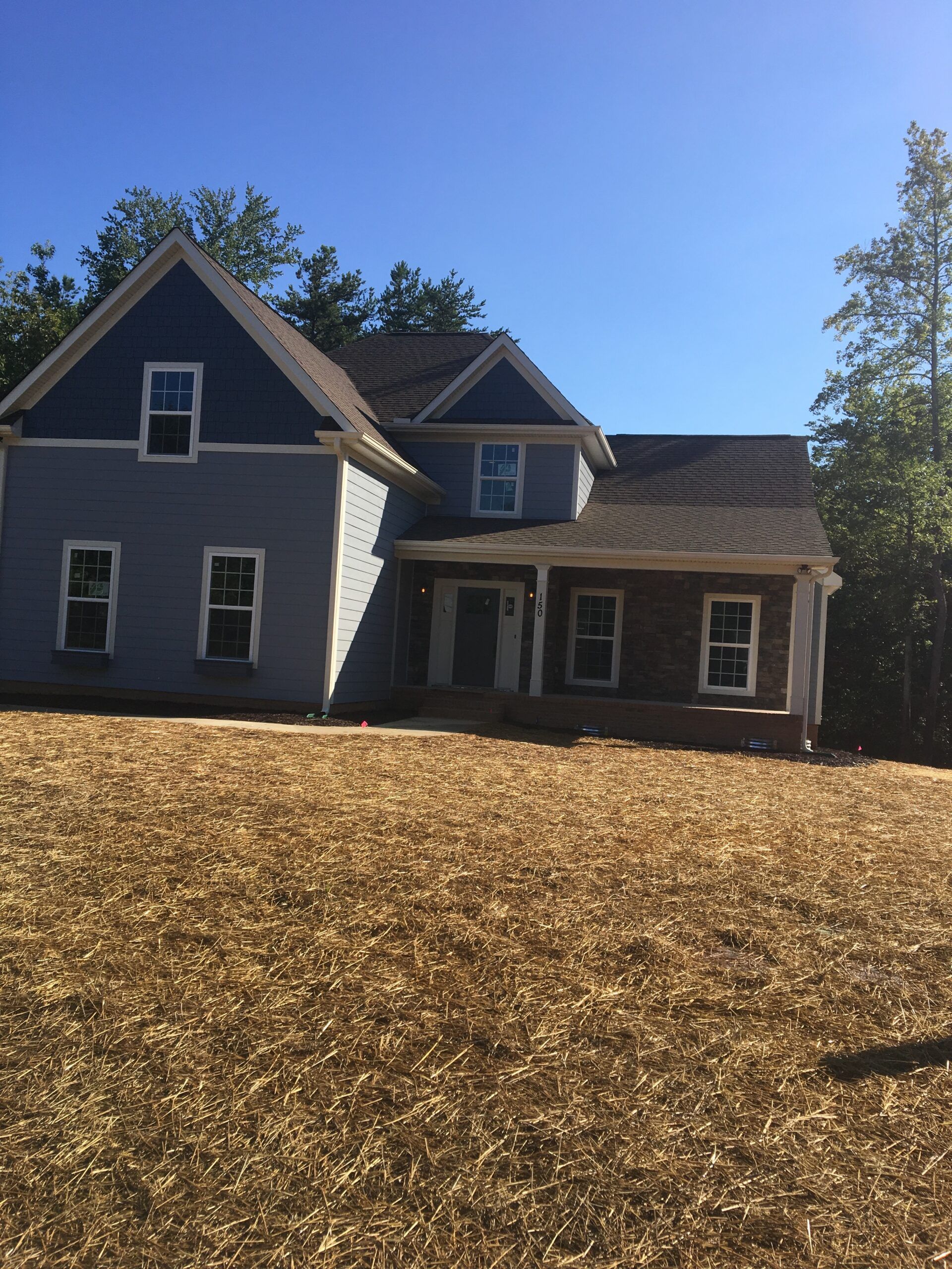 A house with a lot of hay in front of it