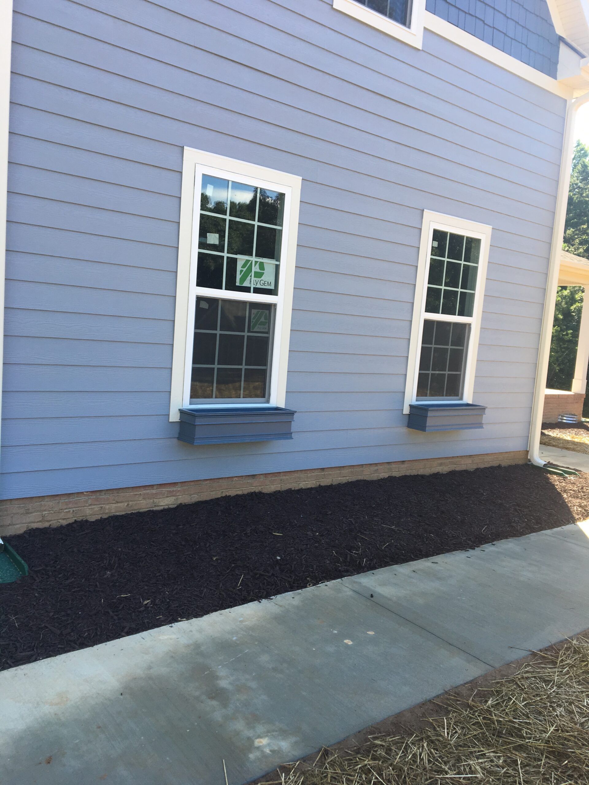 A blue house with white trim and two windows