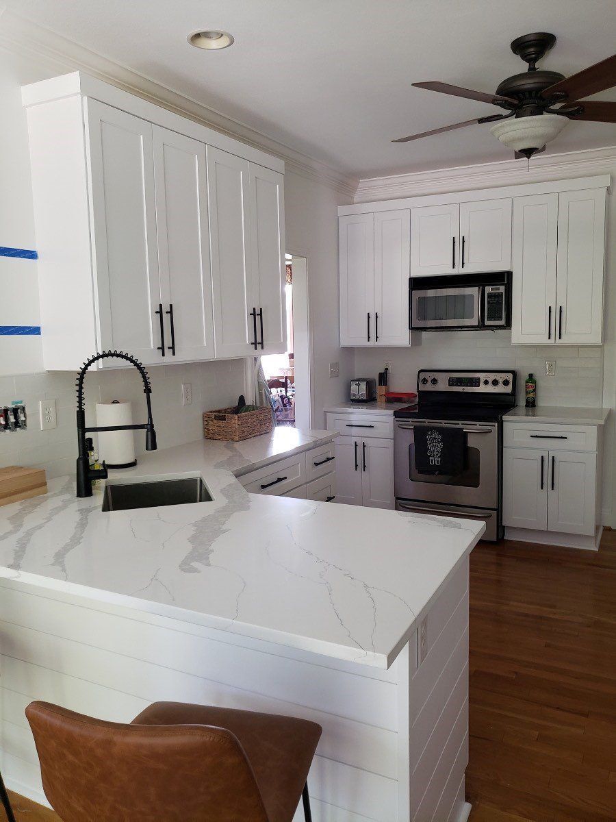 A kitchen with white cabinets and stainless steel appliances