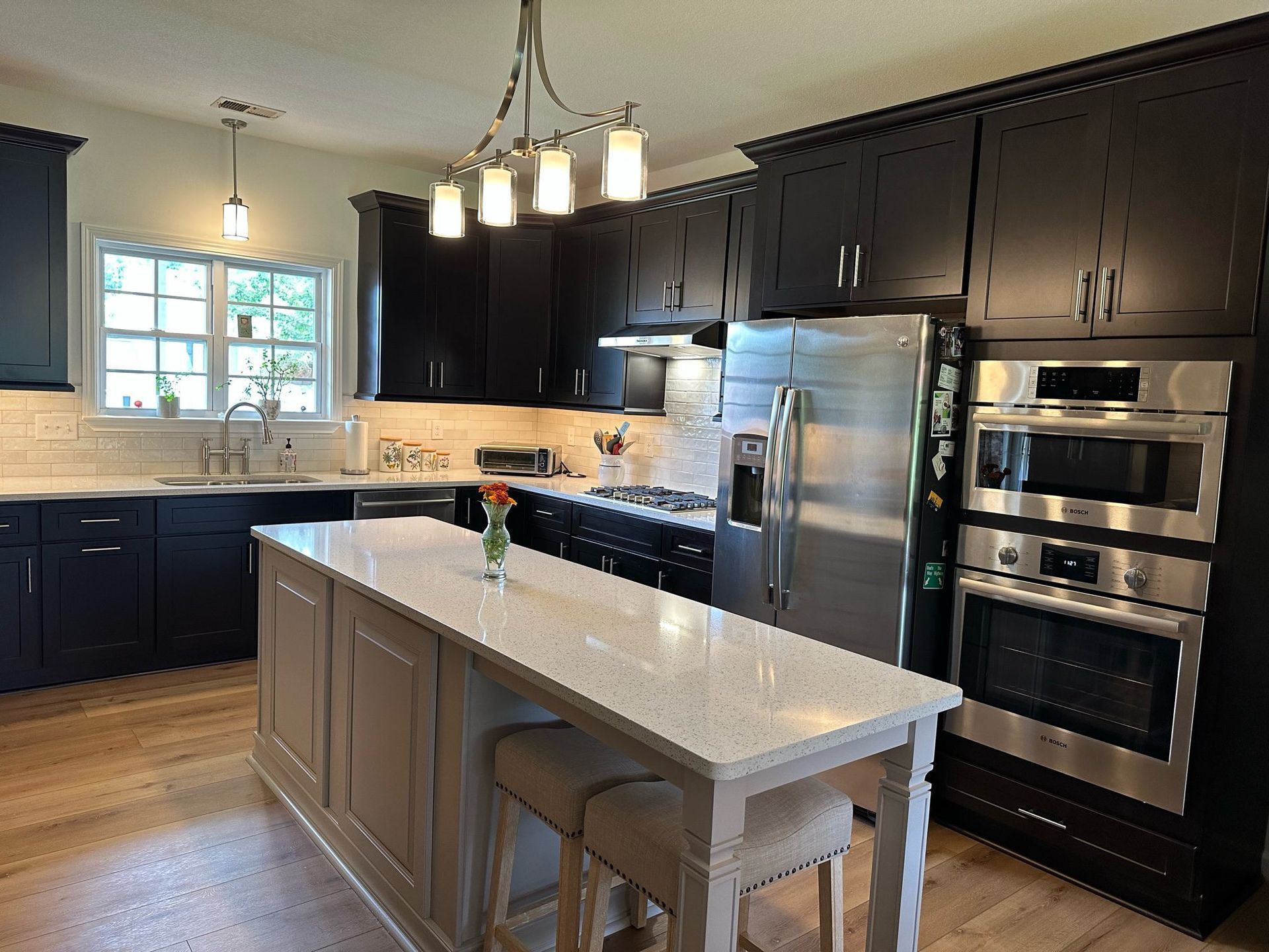 A kitchen with black cabinets and stainless steel appliances