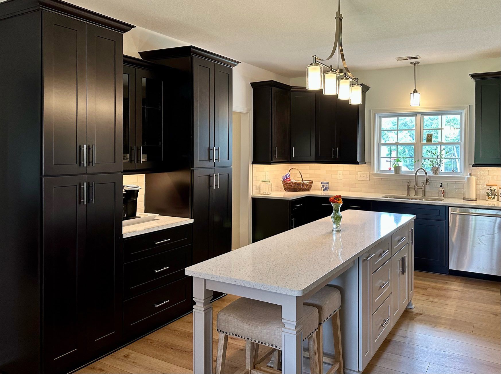 A kitchen with black cabinets and white counter tops