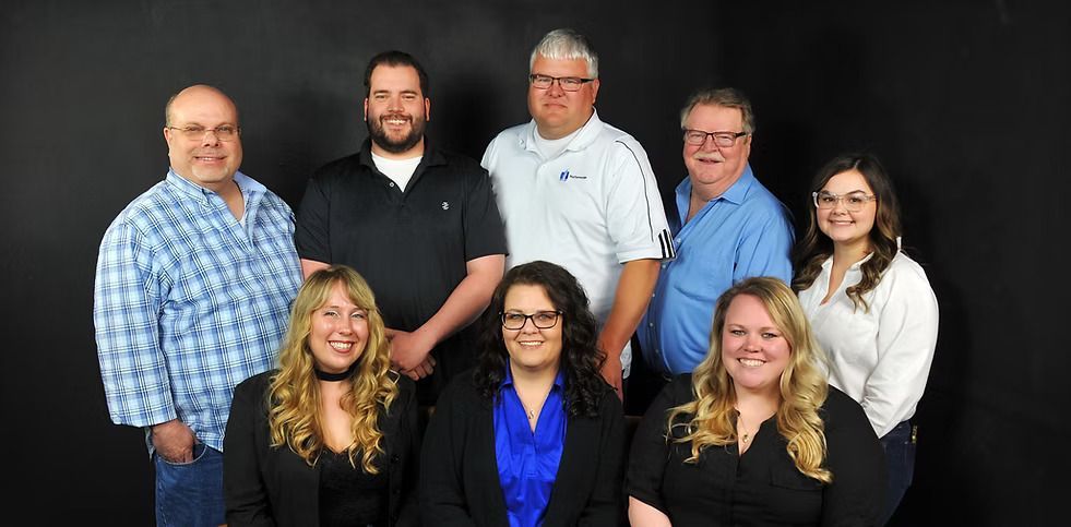A group of people are posing for a picture in front of a black background.