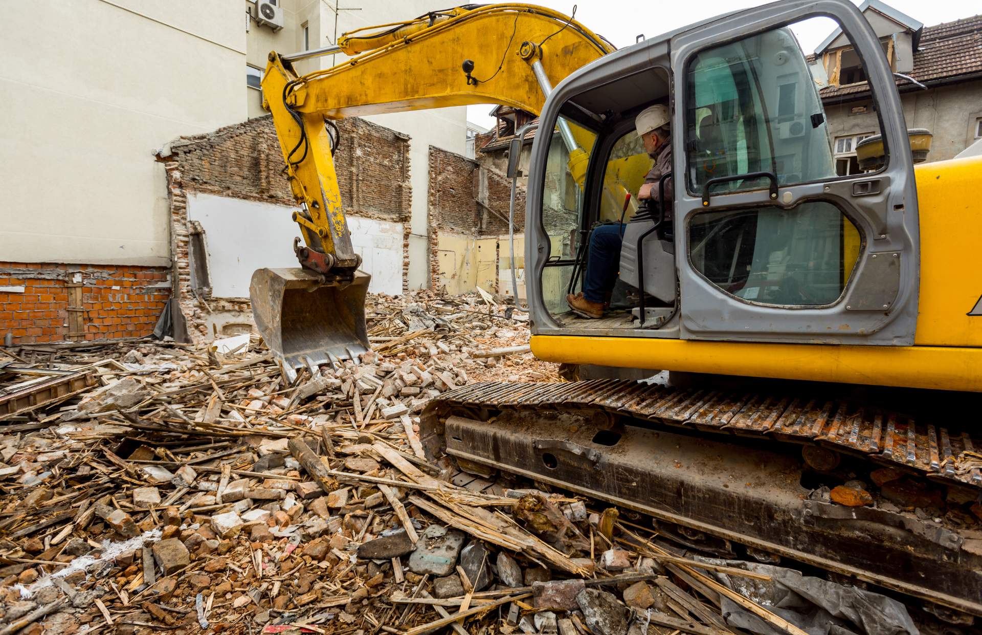 Excavator loading a dump truck with rocks in a quarry; orange machinery.