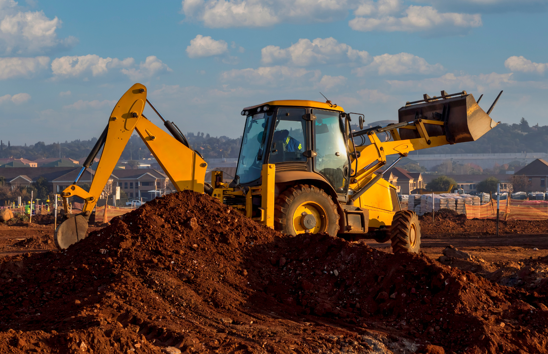 Three yellow mining trucks and an excavator in a quarry.