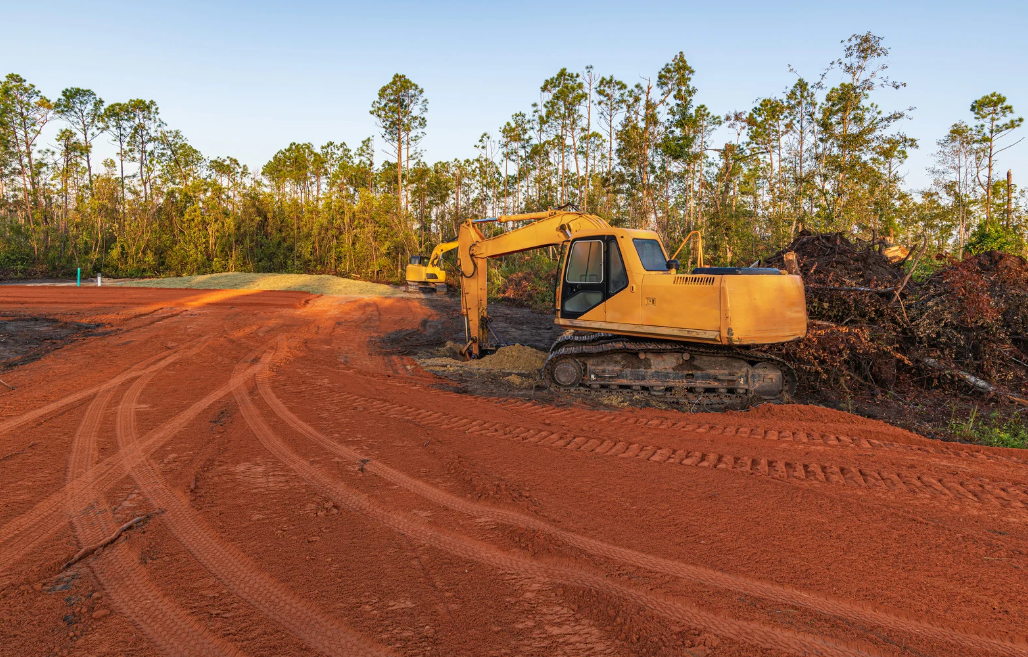 Excavator loading a dump truck with rocks in a quarry; orange machinery.