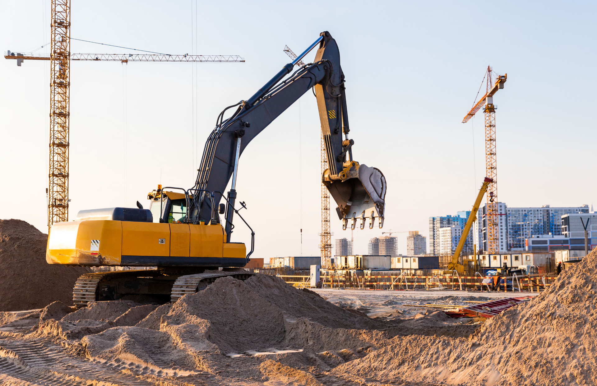 Excavator loading a dump truck with rocks in a quarry; orange machinery.