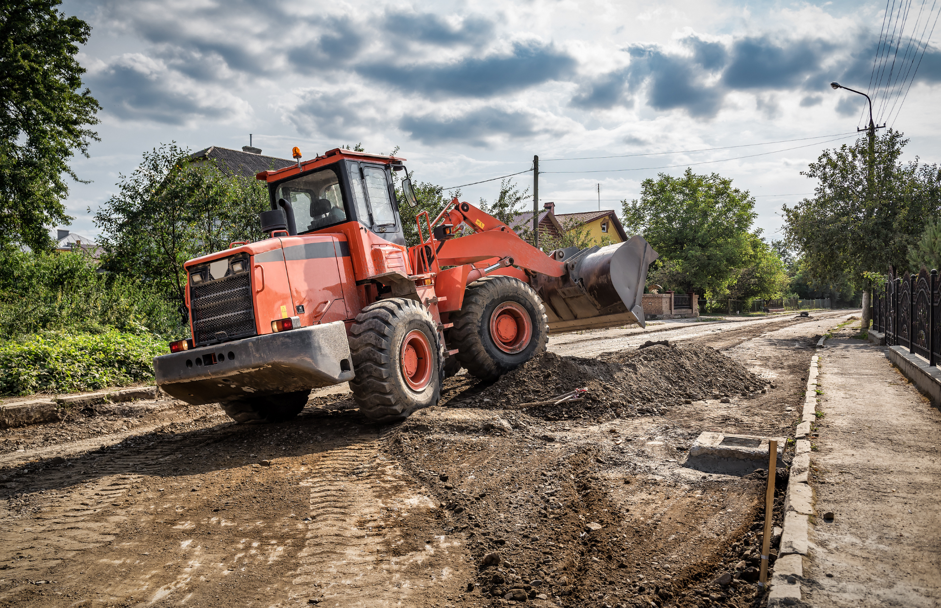 Excavator loading a dump truck with rocks in a quarry; orange machinery.