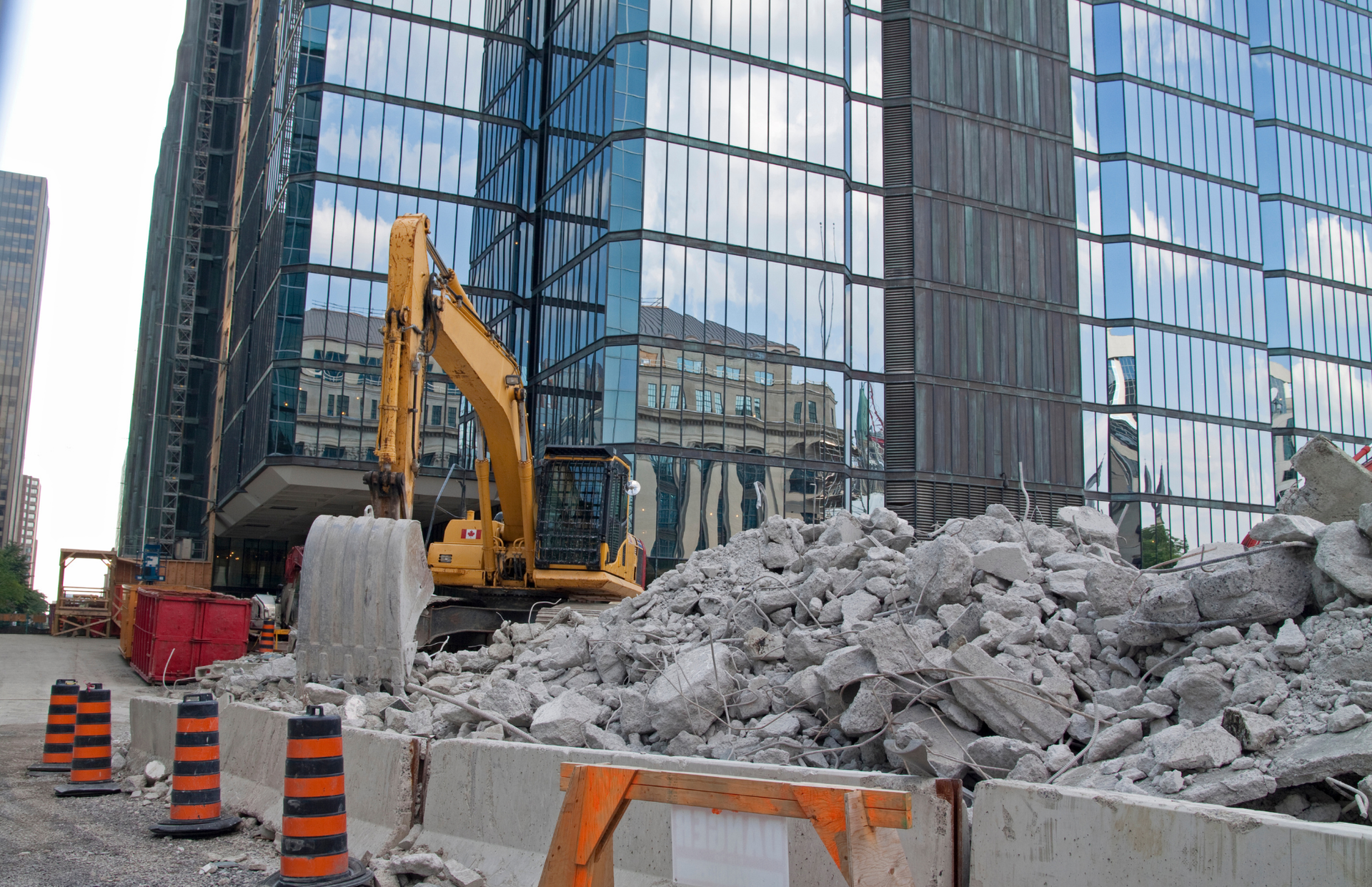 Excavator loading a dump truck with rocks in a quarry; orange machinery.