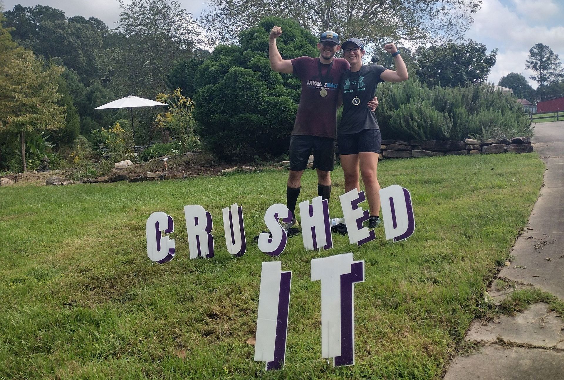 A man and a woman are standing in front of a sign that says crushed it