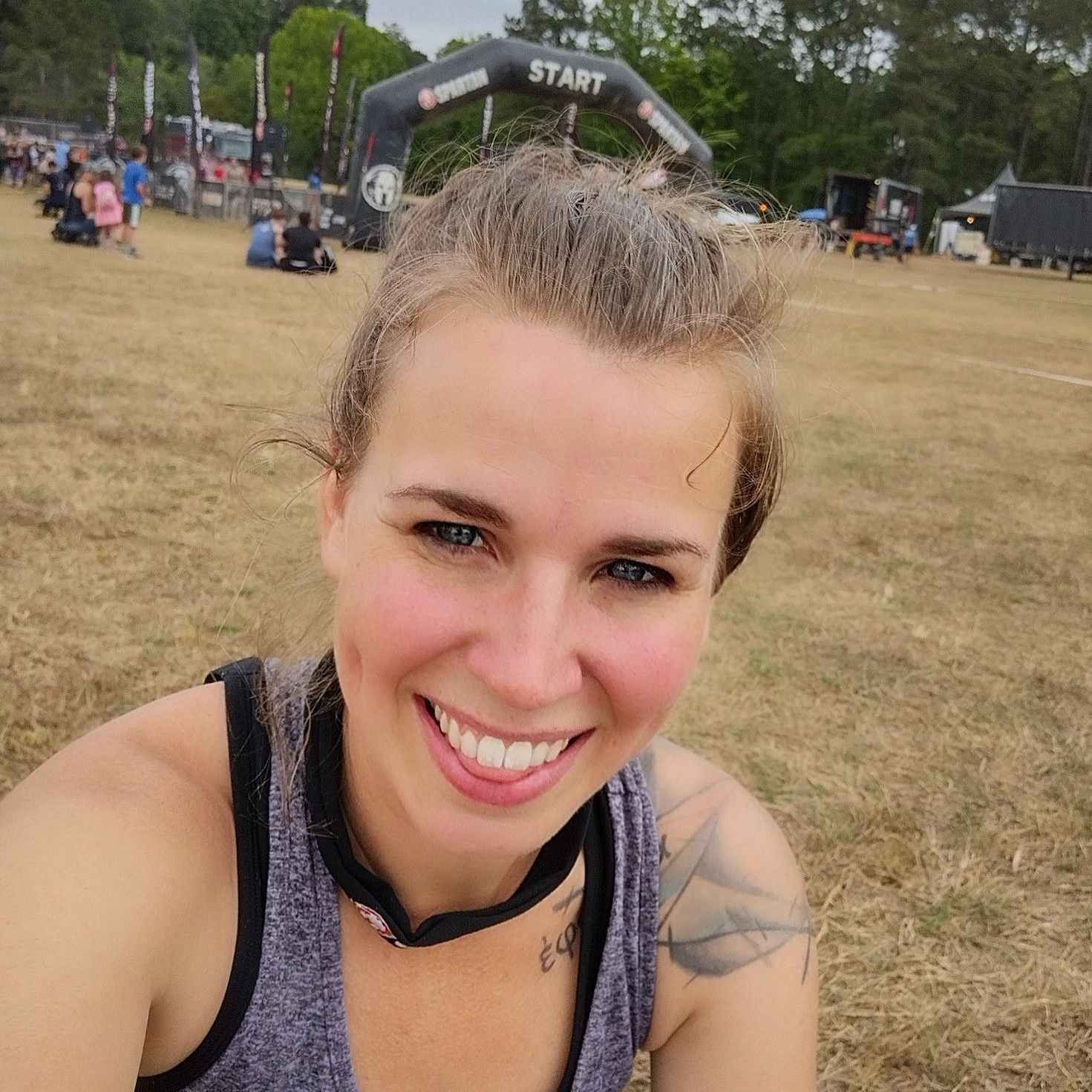 A woman is smiling in front of a start sign