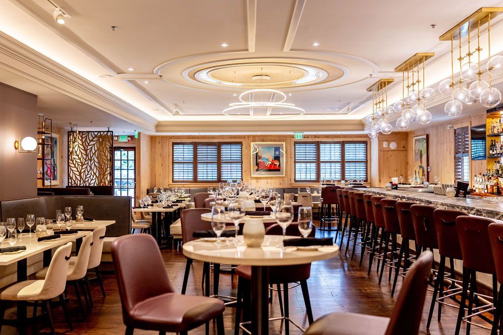 Elegant Vyne Restaurant & Bar interior with tables, bar, lighting, and decorative ceiling.