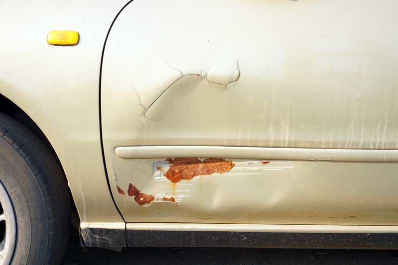 A close up of a car door with rust on it. | B & K Collision