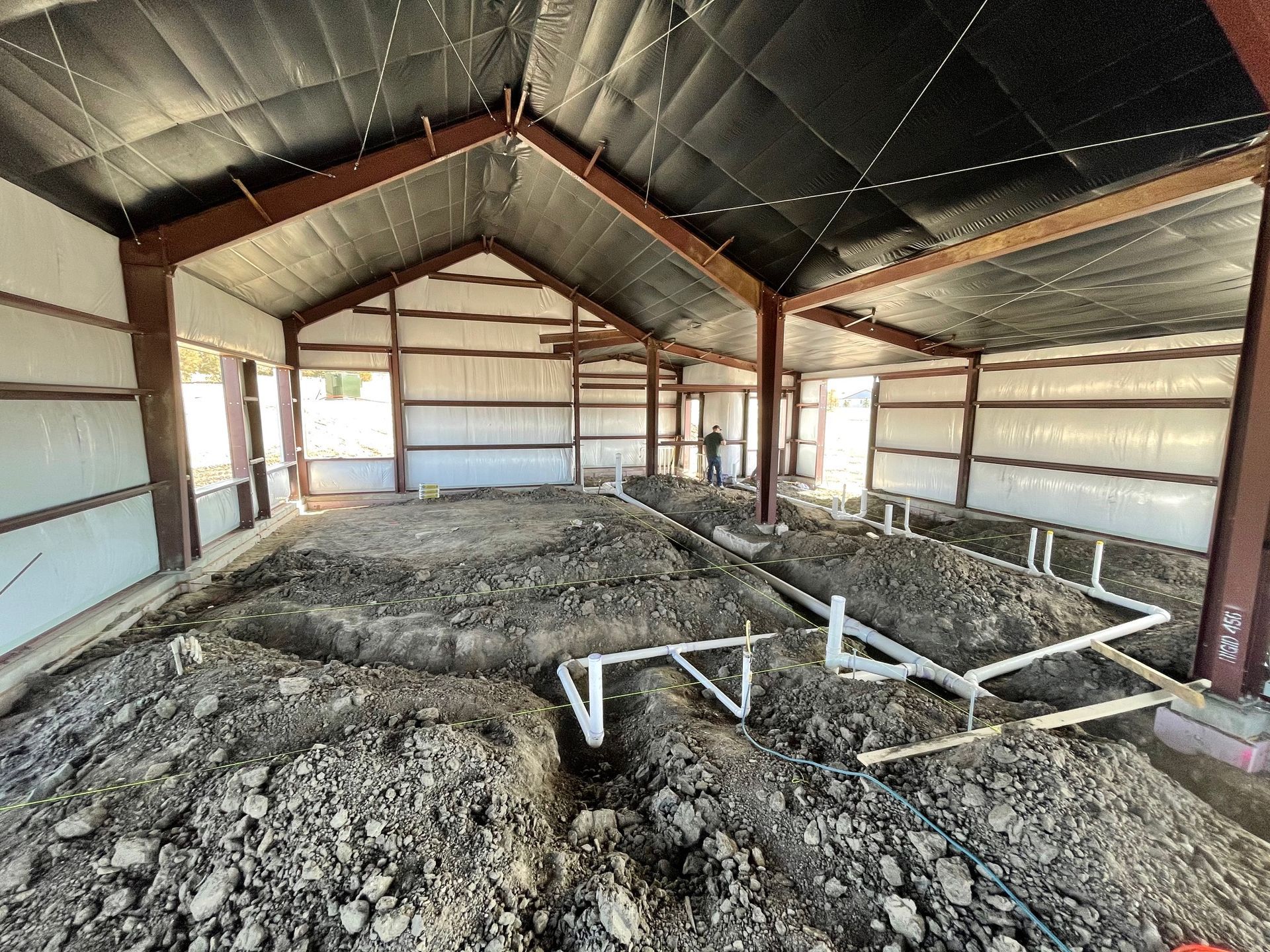 A large building under construction with a lot of dirt on the floor.