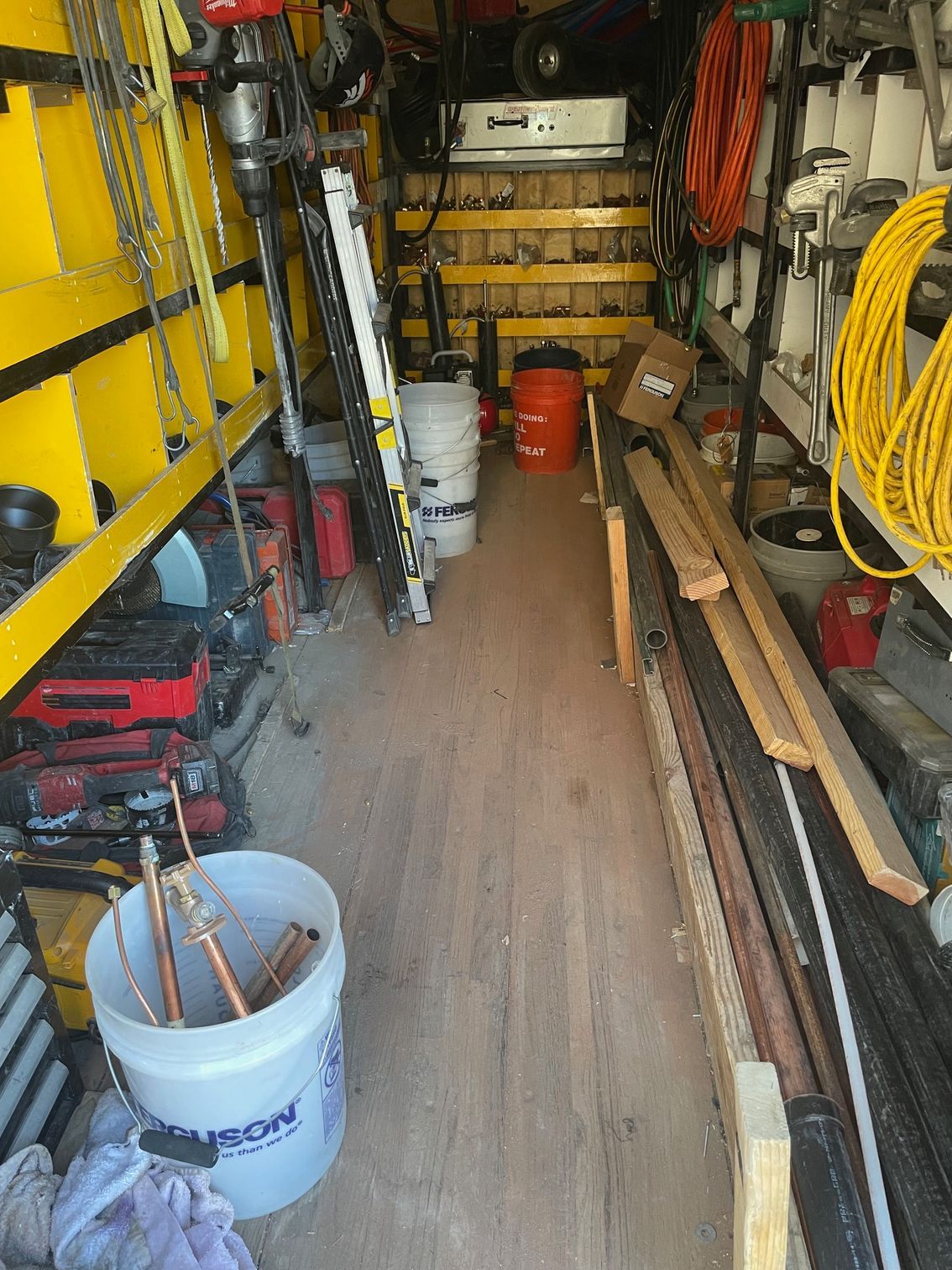 The inside of a truck filled with tools and a bucket of tools.