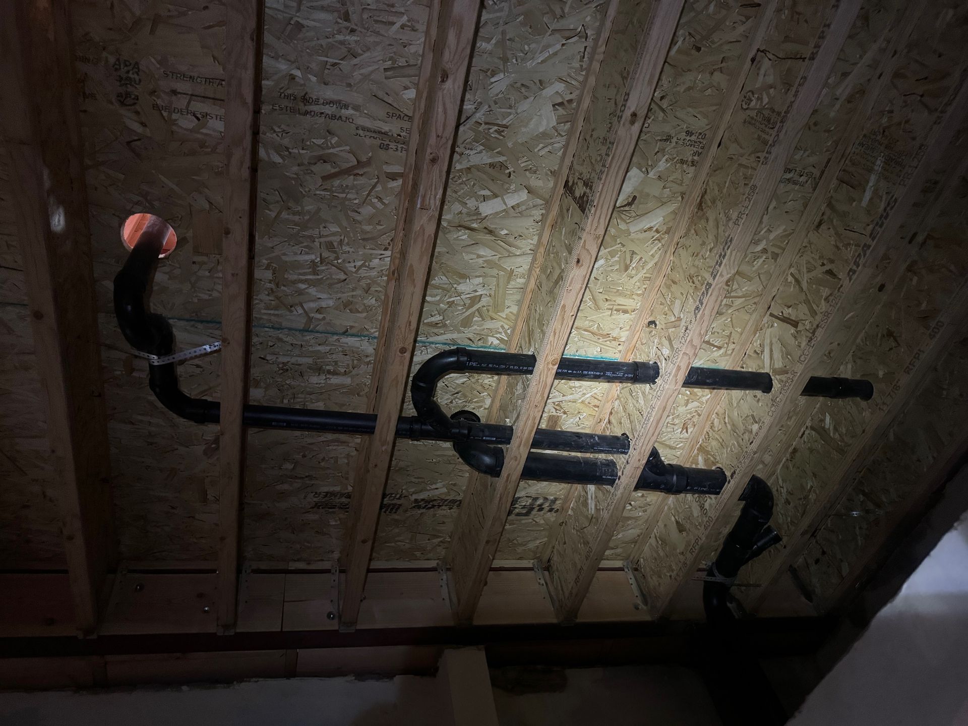 A wooden ceiling with a hole in it and a light shining through it.