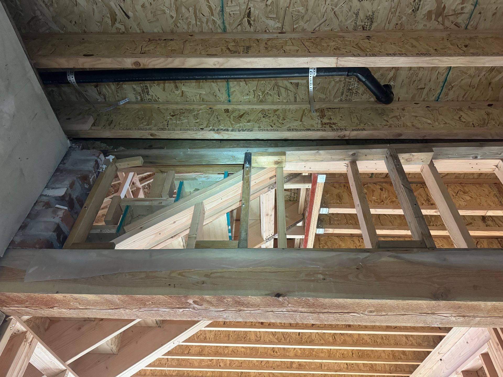 A ladder is hanging from the ceiling of a building under construction.
