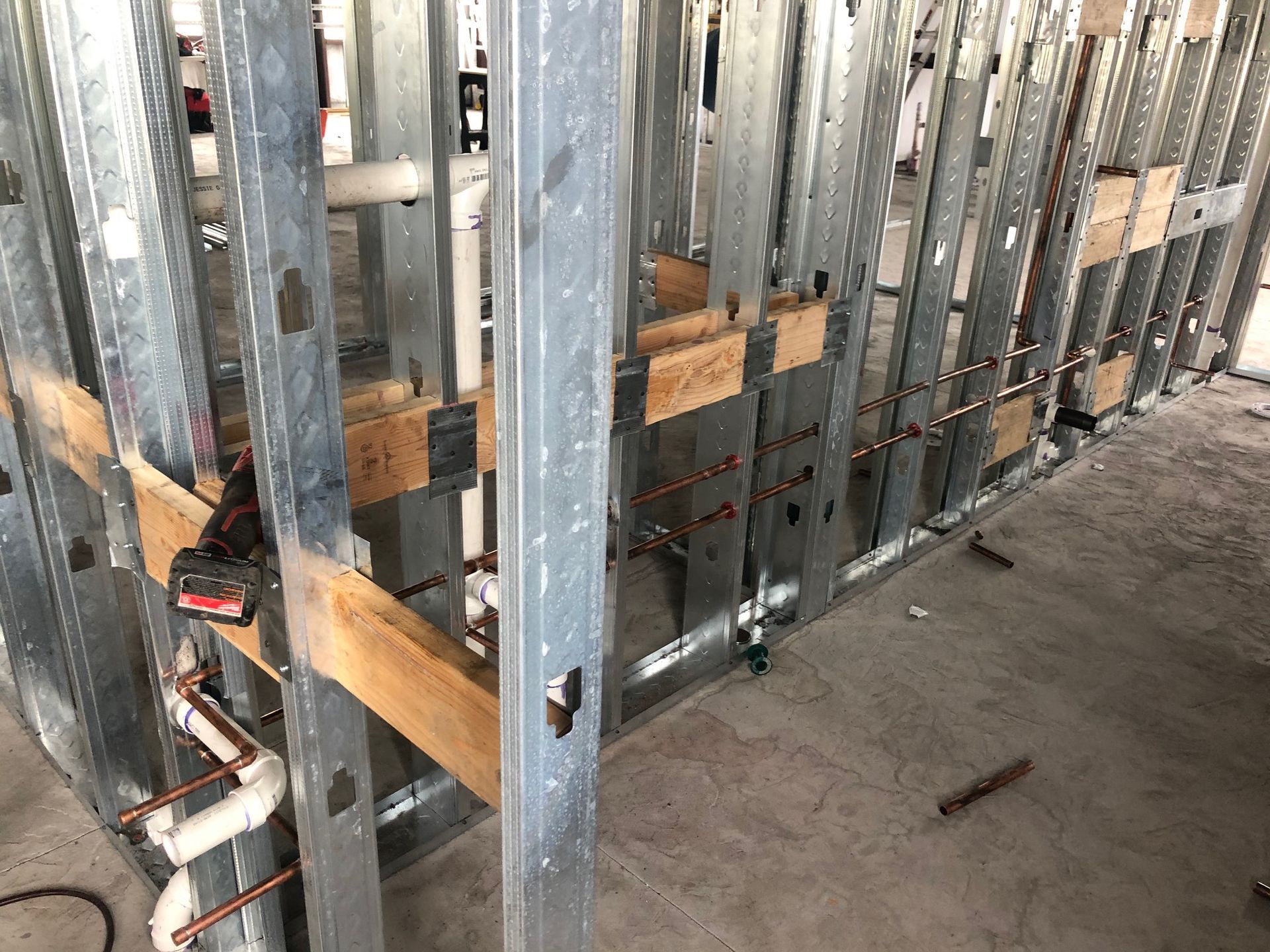 A metal wall with pipes coming out of it is being built.