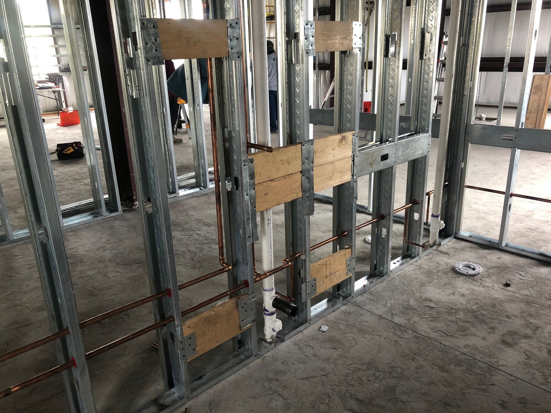 A building under construction with a metal frame and copper pipes.