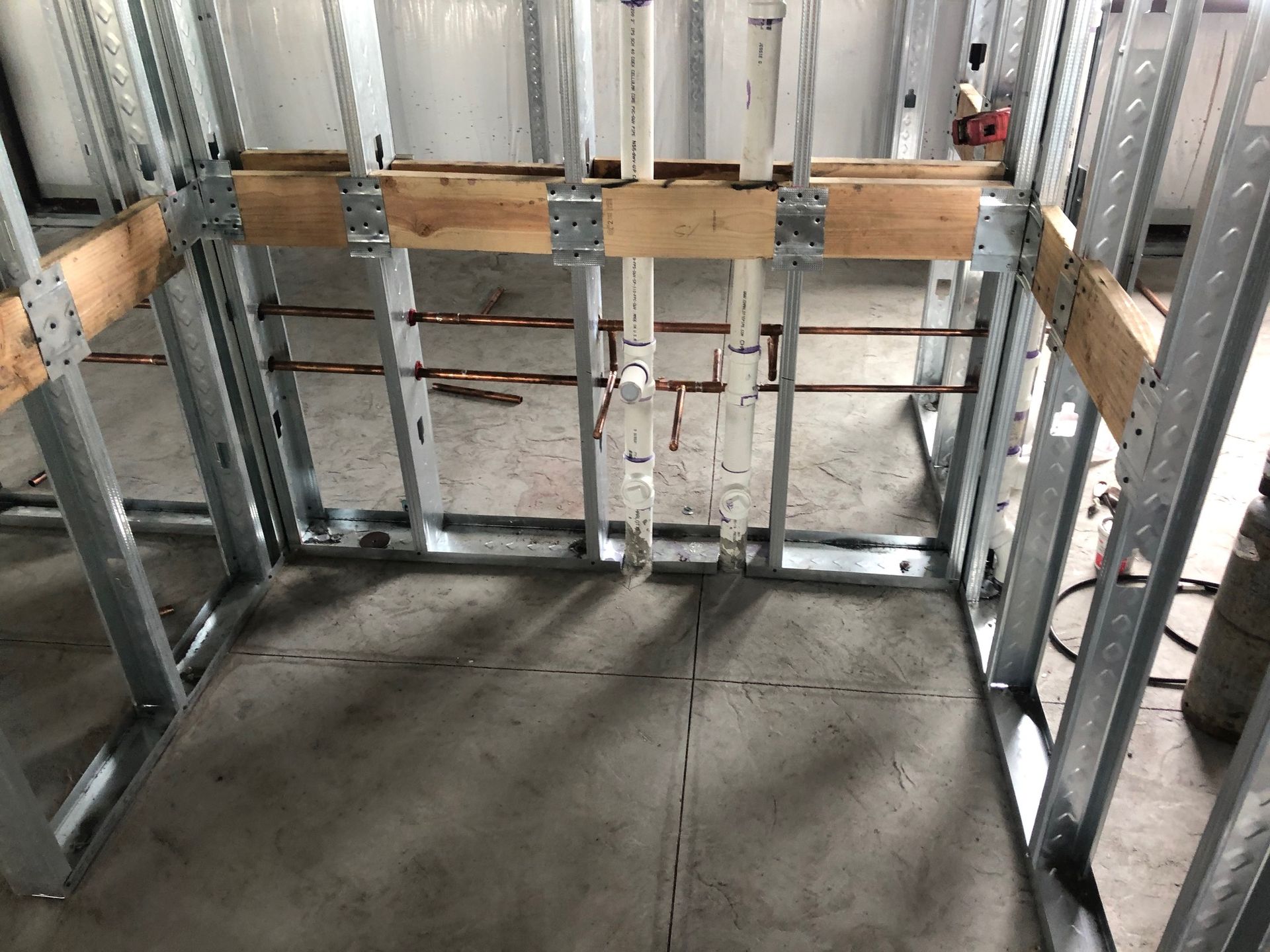 A room under construction with metal frames and wooden beams.