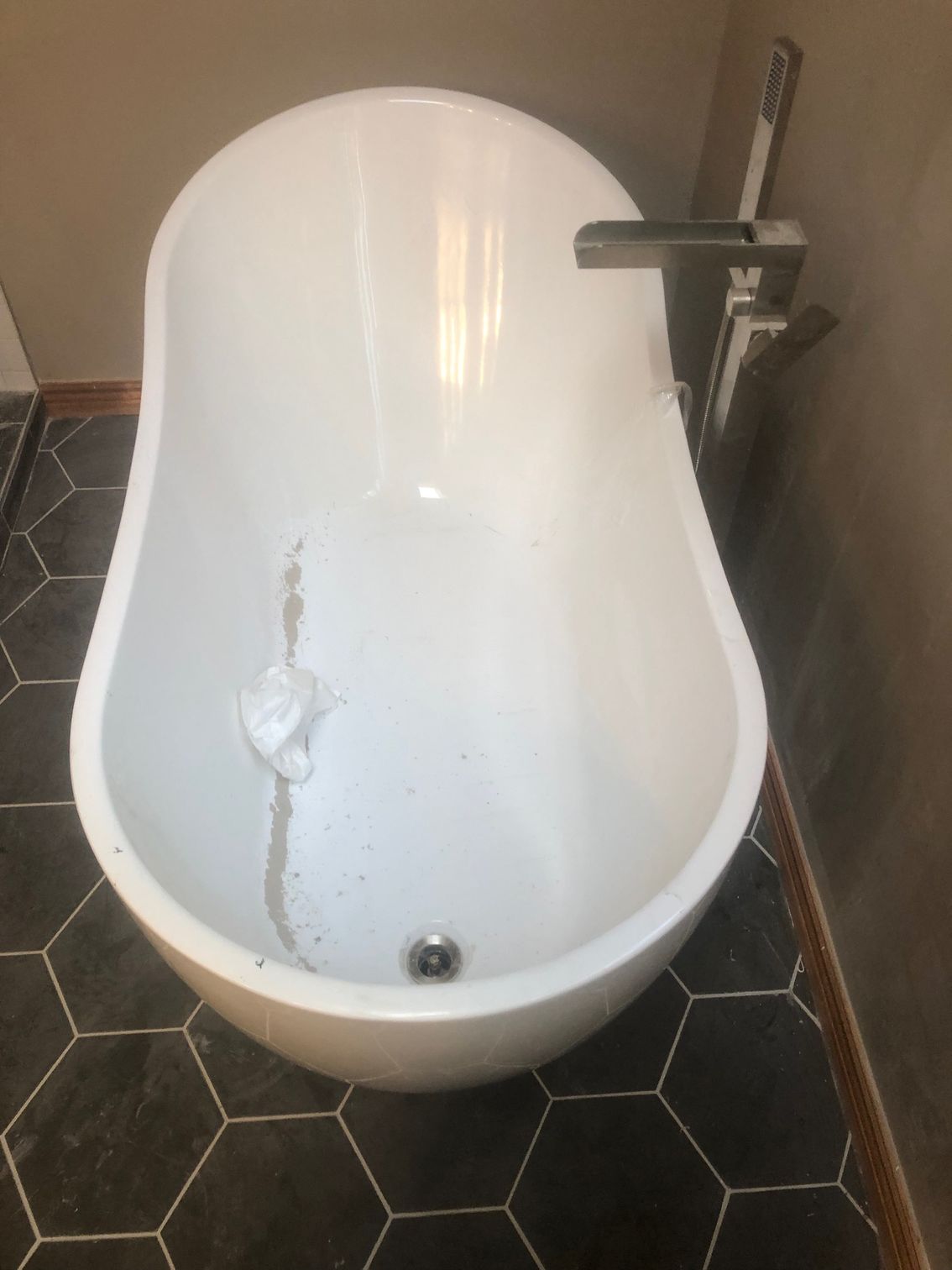 A bathtub is sitting on a tiled floor in a bathroom