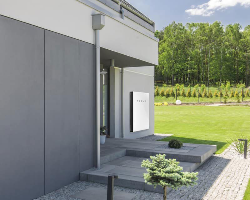 A Tesla Solar Panel Is Mounted On The Side Of A House — Experienced Solar Installers in Tamworth