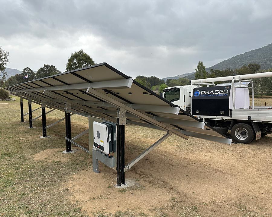 A Phased Truck Is Parked Next To A Row Of Solar Panels — Experienced Solar Installers in Tamworth