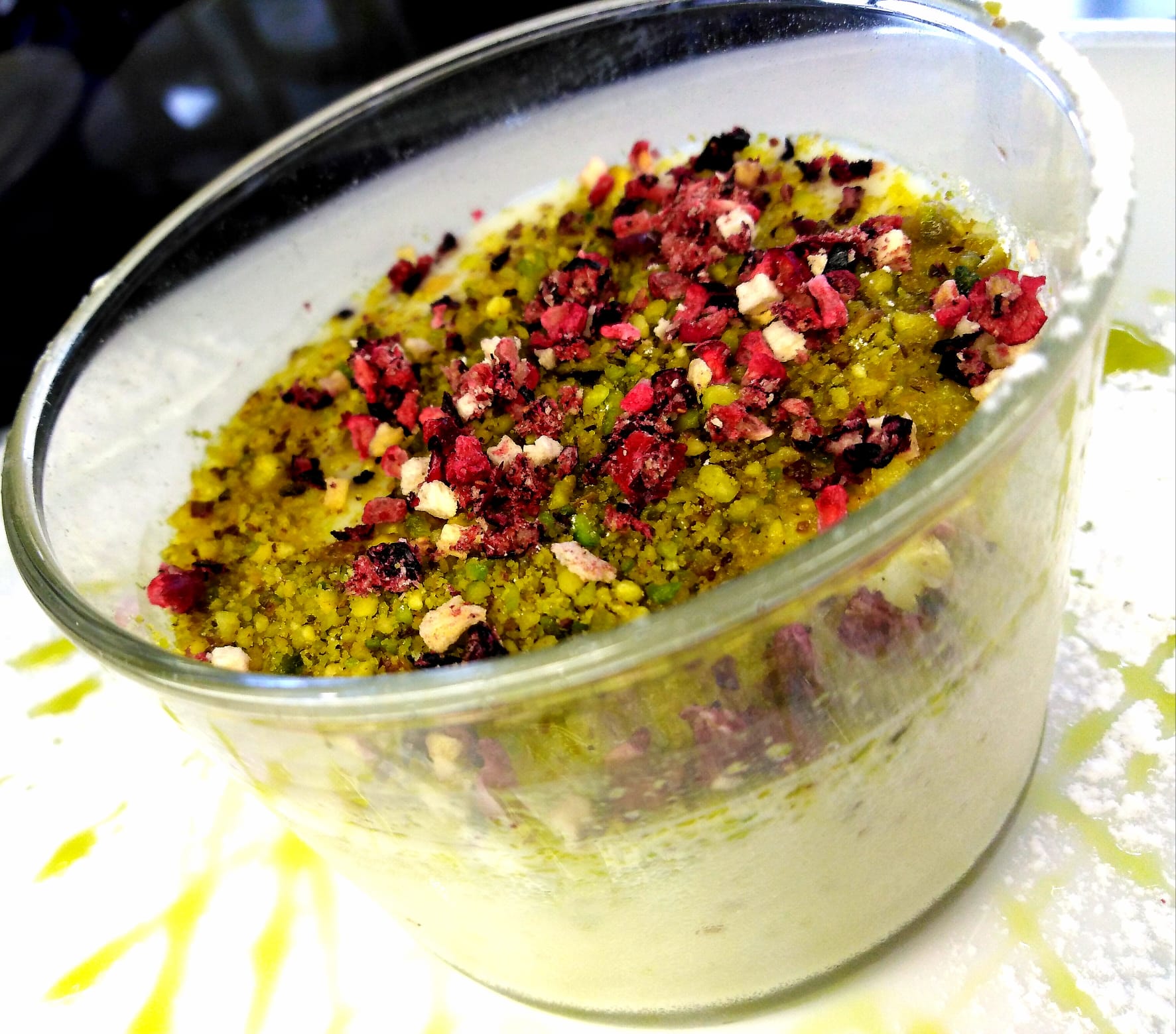 Una ciotola di cibo con pistacchi e bacche sopra