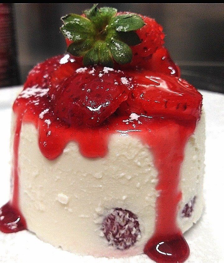 Una piccola torta con fragole sopra