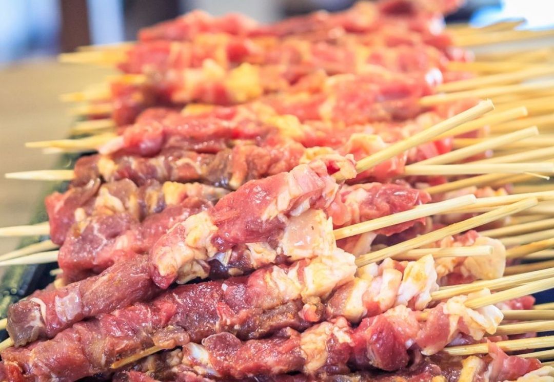 Un mucchio di carne infilzata su uno spiedino su un tavolo.