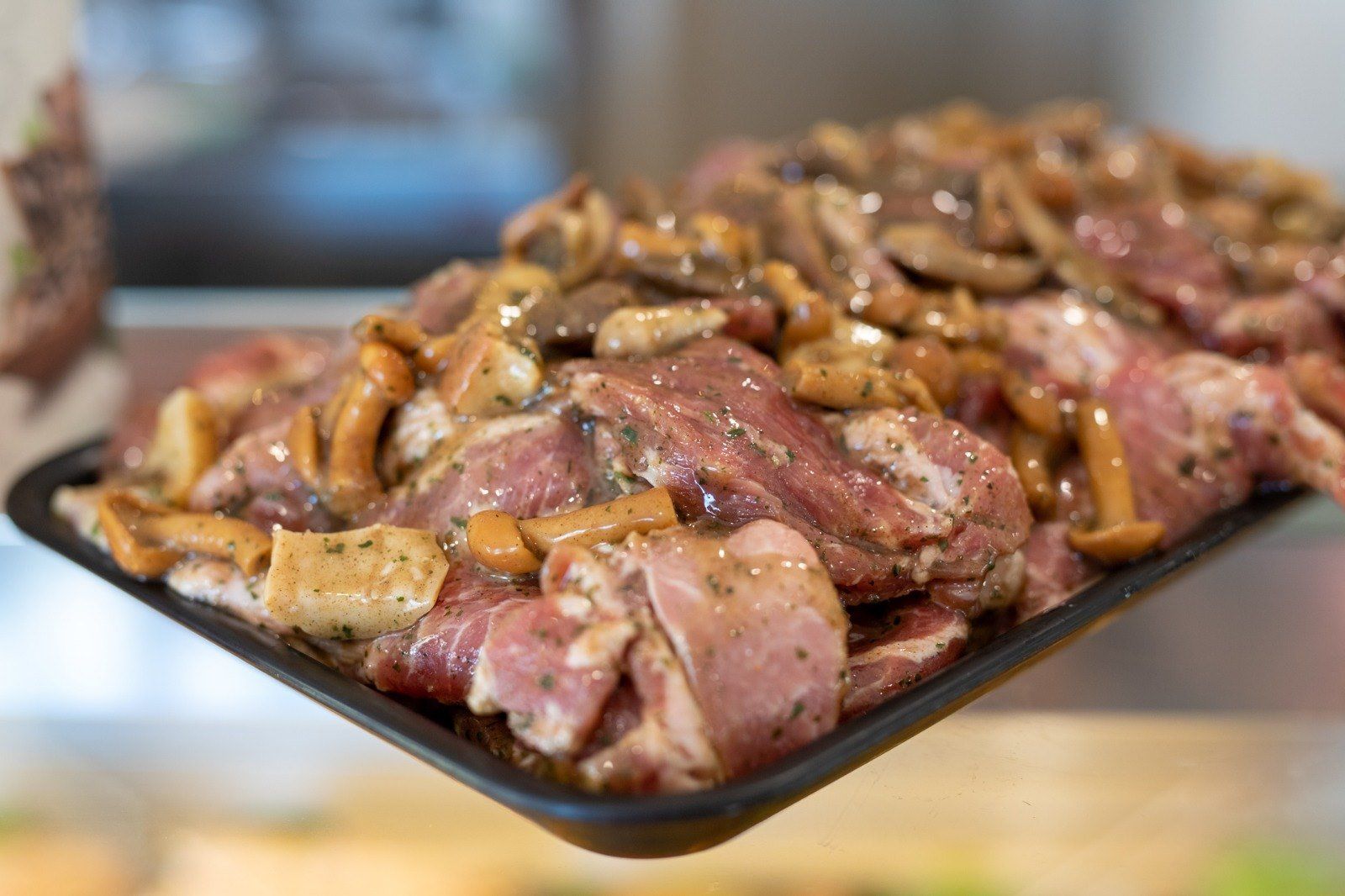 Primo piano di un vassoio di carne e funghi su un tavolo.