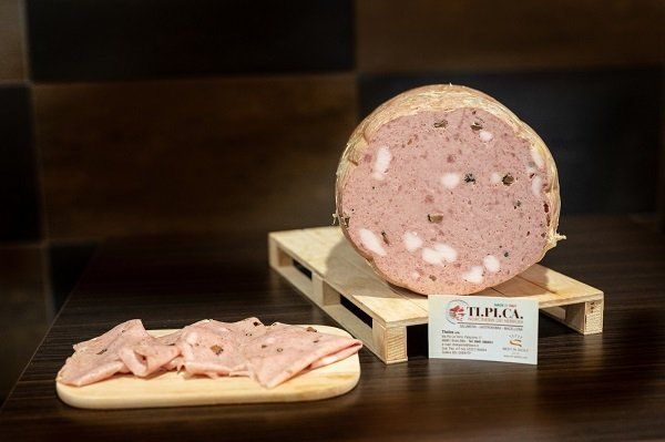 Un grosso pezzo di carne è appoggiato su un pallet di legno.