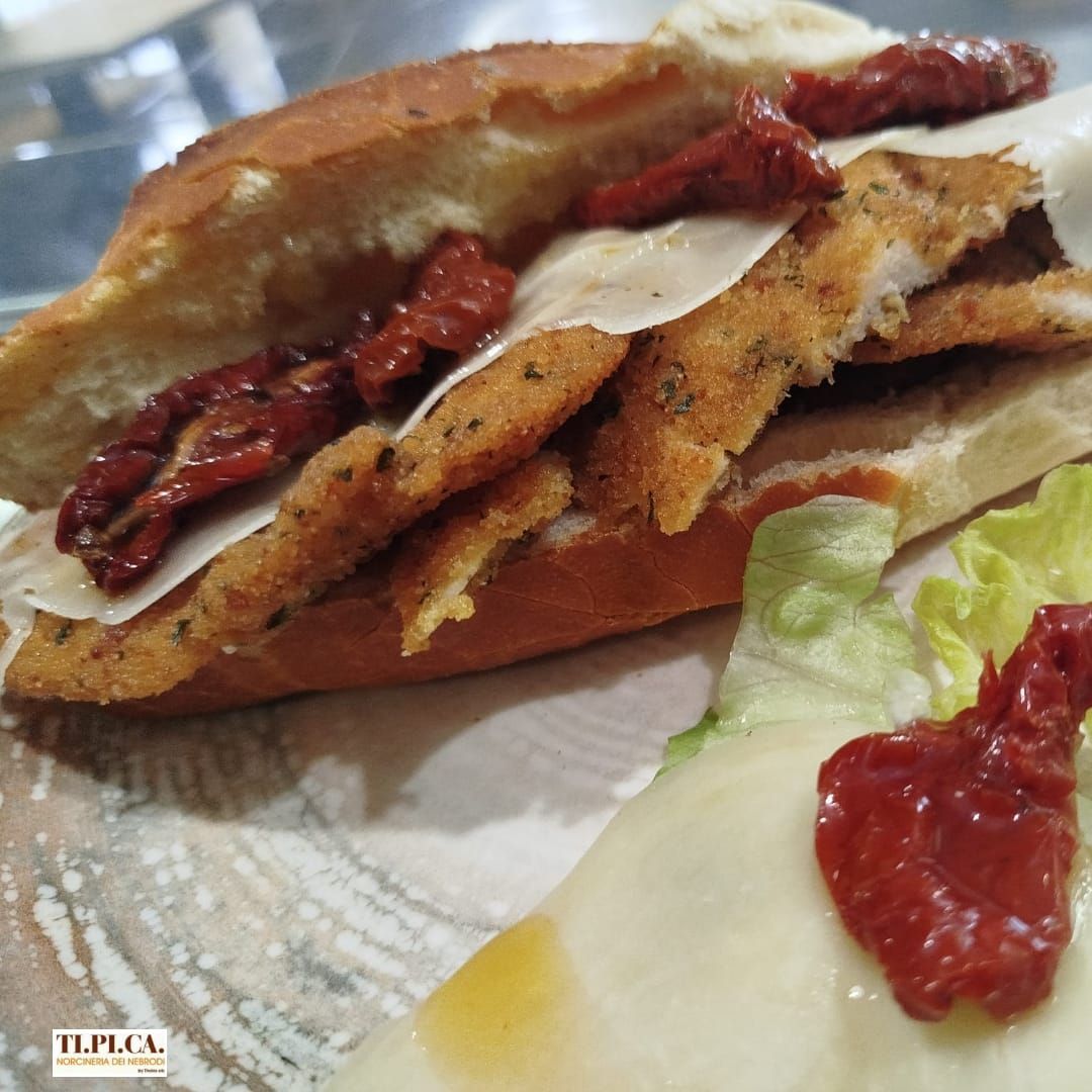 Un primo piano di un panino al pollo con lattuga e salsa di pomodoro