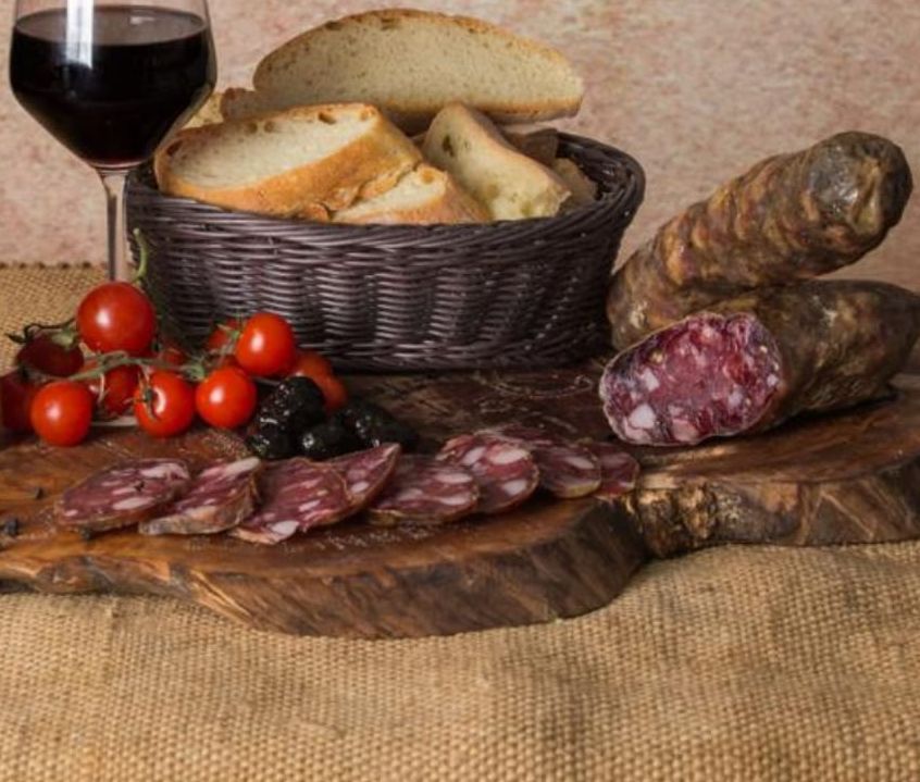 Un cesto di pane è accanto a un bicchiere di vino