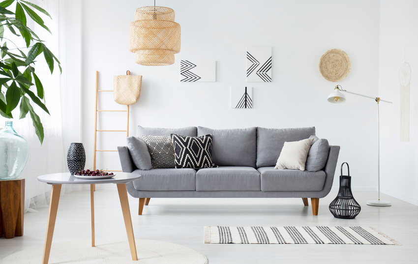 A living room with a couch , table and rug.