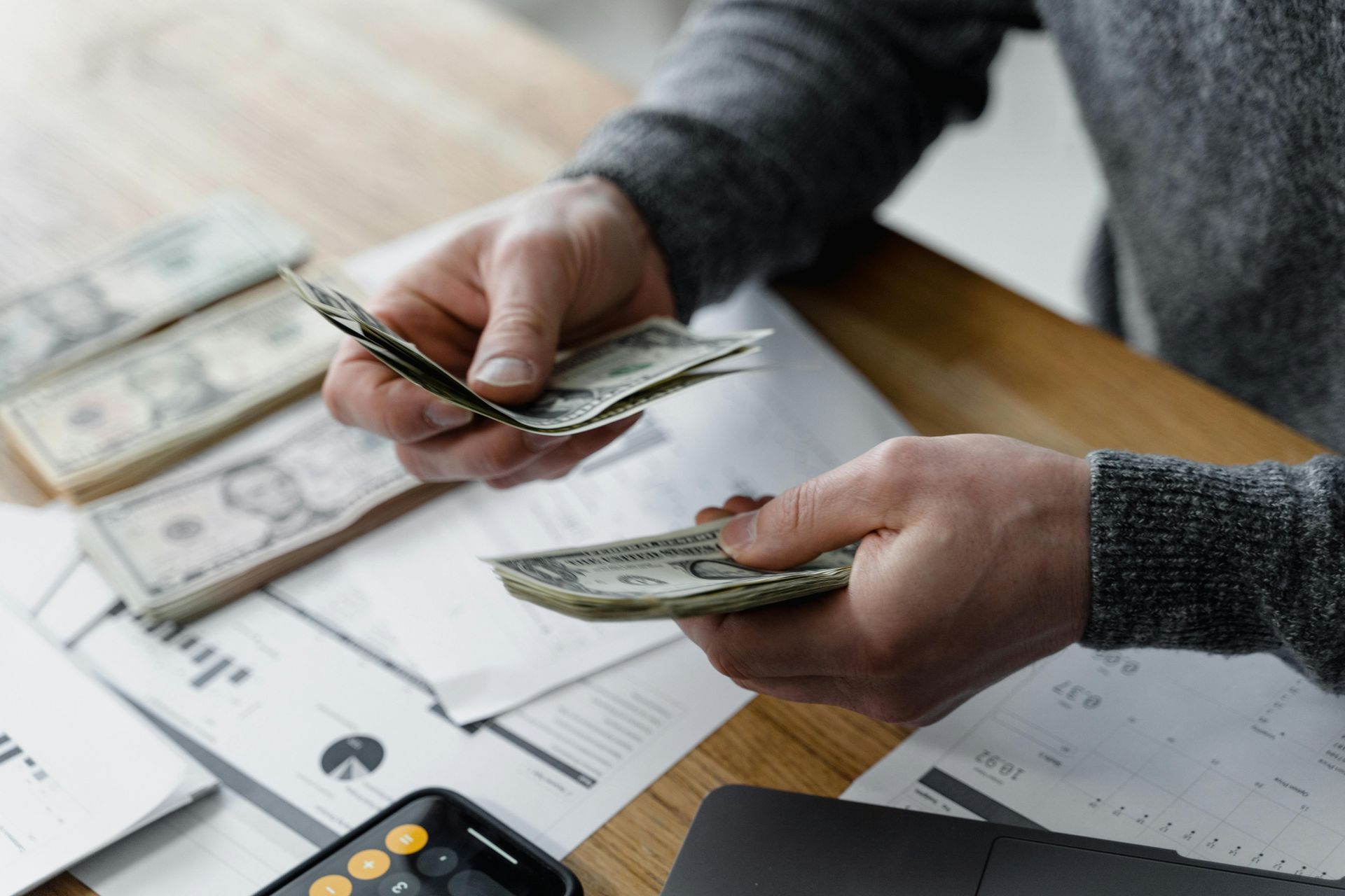 Two people exchange cash over a floor plan clipboard at a home inspection site