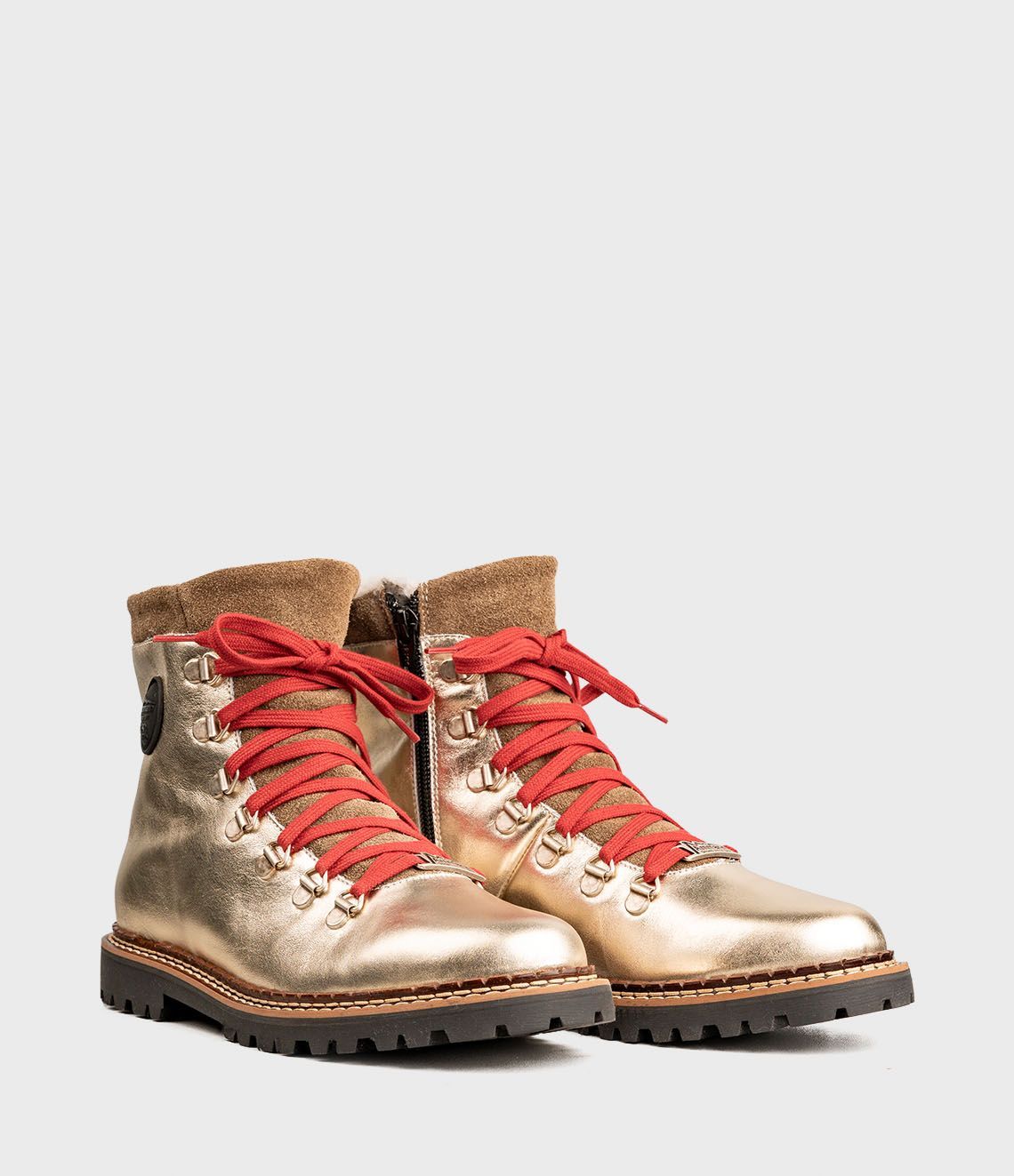 Bottes de randonnée dorées avec lacets rouges, bordure en fourrure et semelles noires.