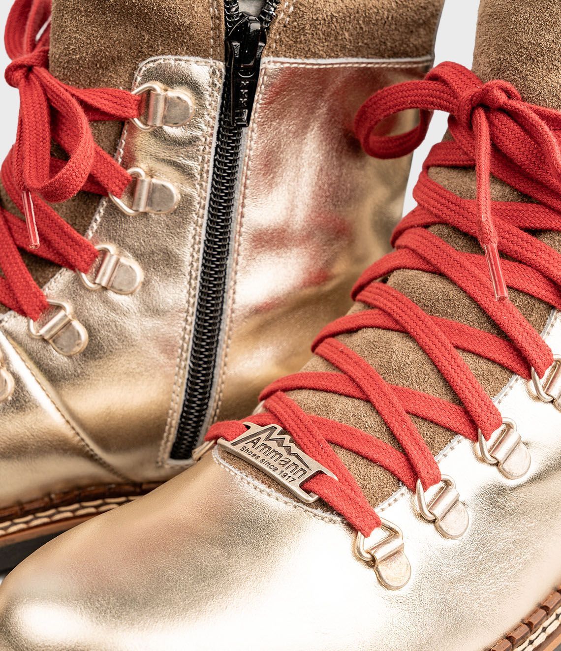 Bottes de randonnée dorées avec lacets rouges, bordure en fourrure et semelles noires.